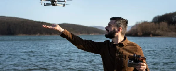 Hombre elevando la mano bajo dron en el aire